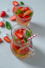 glass mix cocktail strawberry, lime, grapefruit. on the table pieces of strawberries, mint, ice.Isolated.High quality photo