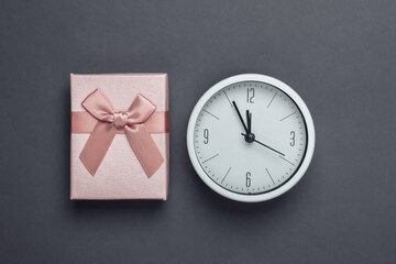 Christmas, New Year theme. Gift box with clock on a gray background. Top view