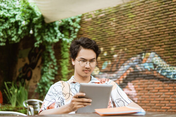 Smiling freelancer using tablet for work when working outdoor