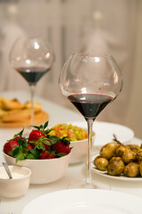 Table setting with red wine and strawberries.Vertically.