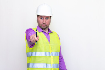 Portrait middle age of caucasian worker wearing hard hat holding pen makes all kinds of grimaces on white studio background.