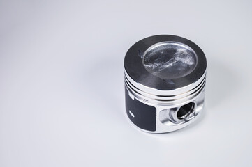 Close-up of the new internal combustion engine piston on a gray gradient background. The concept of new spare parts of the internal combustion engine