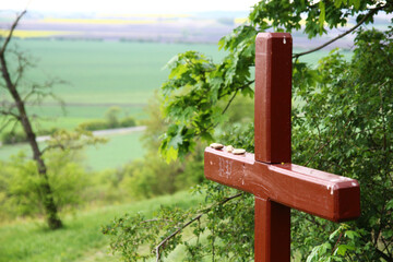 A view from the nature trail of the Chotuc hill (south slope) - natural monument in the Central Bohemian region near Křinec town in the Czech Republic. Brown wooden cross in the foreground.