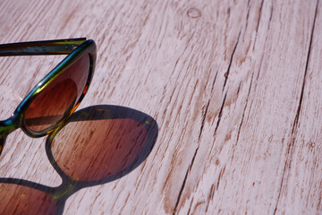 Sunglasses reflected  onto a wooden background
