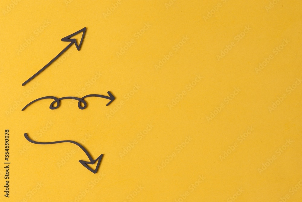 Poster closeup shot of different arrow signs with a copy space isolated on yellow background