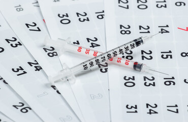 Two Syringe on a monthly calendar close-up. Vaccination