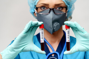medical doctor nurse woman wearing protective mask and gloves - holding negative and positive...