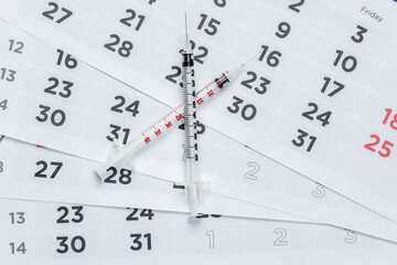 Two Syringe on a monthly calendar close-up. Vaccination