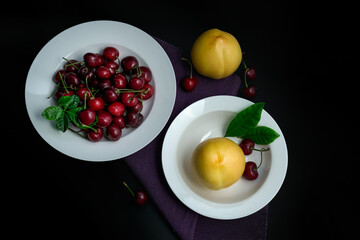 Peaches and cherries on a white dinner plate