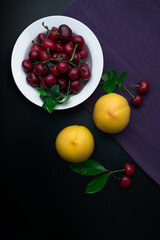 Peaches and cherries on a white dinner plate