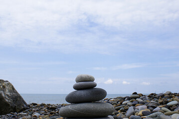 Pyramid of round stones on the seashore, the concept of harmony, balance and meditation.