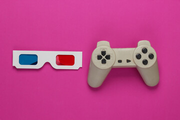 Anaglyph disposable paper 3d glasses and retro gamepad on pink background. Top view