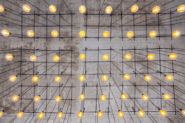 Ceiling lamps background. Unusual ceiling. Soft light of many bulbs. Grey faded backdrop. Yellow...