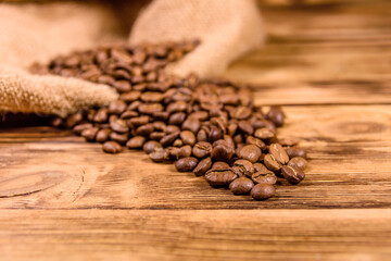 Sackcloth and scattered coffee beans on wooden table