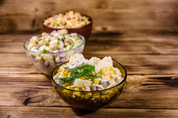 Set of festive mayonnaise salads on wooden table
