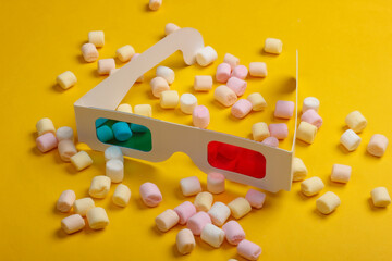 Anaglyph disposable paper 3d glasses with marshmallows on a yellow background. Pop art, minimalism