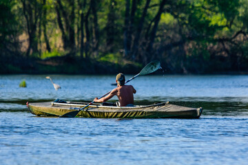 Fototapeta premium Young man kayaking on a river at summer