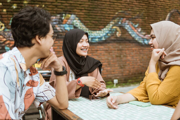 veiled female students smile while chatting with group members