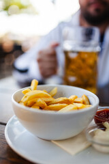 french fries with sauce and glass of cold beer on a wooden table