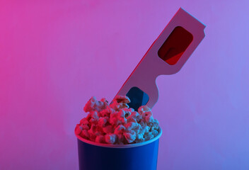 Movie time. Cardboard bucket of popcorn with Stereoscopic anaglyph disposable paper 3d glasses in...