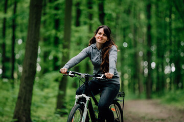 Naklejka premium woman in medical mask rides a bicycle in the park