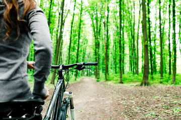 woman in medical mask rides a bicycle in the park