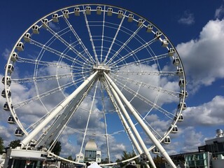 an isolated ferris wheel at daylight with a background of blue cloudy sky, Old Port ,Montreal