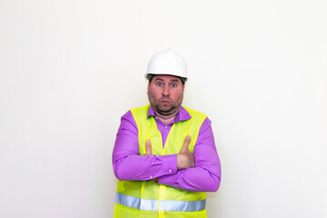 Curious crossed his arms about himself engineer makes all kinds of grimaces on a white background.