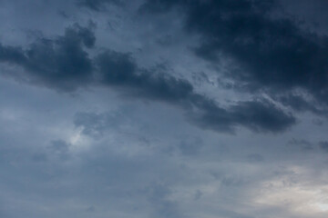 Obraz premium Beautiful dramatic gray and white clouds on blue sky, variety of shapes, silhouettes and shades at sunset time