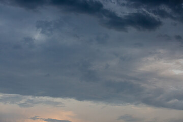 Beautiful dramatic gray and white clouds on blue sky, variety of shapes, silhouettes and shades at sunset time