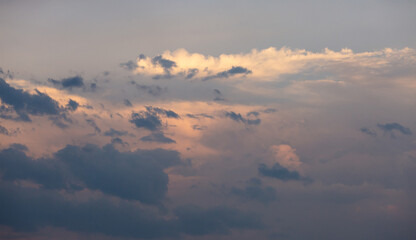 Beautiful dramatic gray and white clouds on blue sky, variety of shapes, silhouettes and shades at sunset time