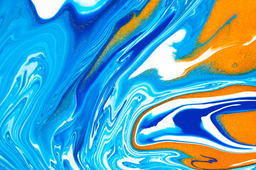 Fluid art texture. Background with abstract swirling paint effect. Liquid acrylic picture that flows and splashes. Mixed paints for baner or wallpaper. Blue, golden and white overflowing colors.