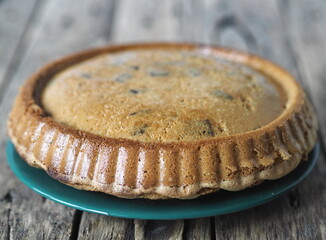 Round homemade Apple pie on a rustic wooden background.Classic dessert of dough with apples and...