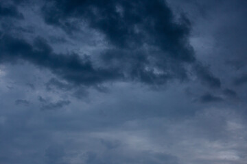 Beautiful dramatic gray and white clouds on blue sky, variety of shapes, silhouettes and shades at sunset time