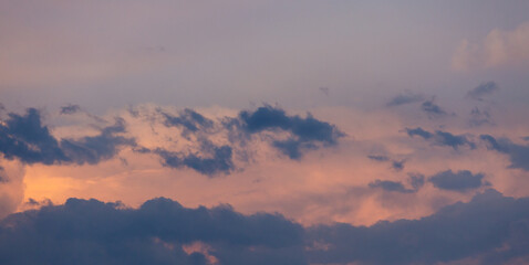 Beautiful dramatic gray and white clouds on blue sky, variety of shapes, silhouettes and shades at sunset time