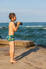 Boy photographing sea with camera