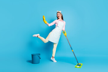 Full length photo of positive energetic girl wash floor mop imagine she dancer dance wear latex gloves pink shirt pants trousers headband isolated over blue color background