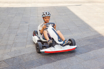 Happy boy riding an electric car © Oleh
