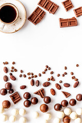 Candy background with chocolate and coffee on white desk top view frame pattern. Cafe concept. Copy space