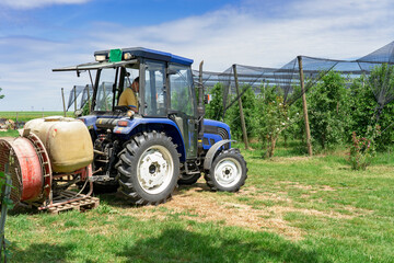 Farmer Preparing Tractor for Orchard Spraying in Springtime