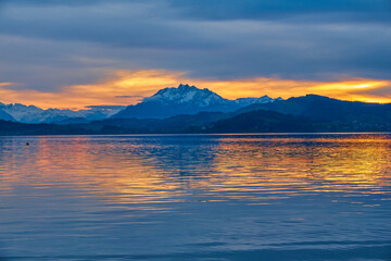 Beautiful landscape with a lake surrounded by high mountains and a cloudy sky at sunset, Switzerland, Lake Zug