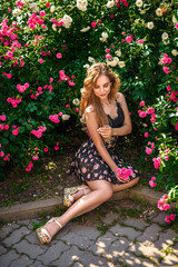 Obraz na płótnie Canvas Beautiful happy young woman enjoying smell in a flowering spring garden