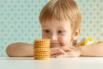 the blond child smiles and nibbles on the table