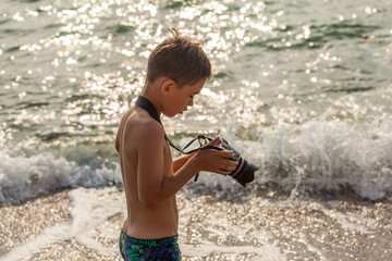 Boy photographing sea with camera