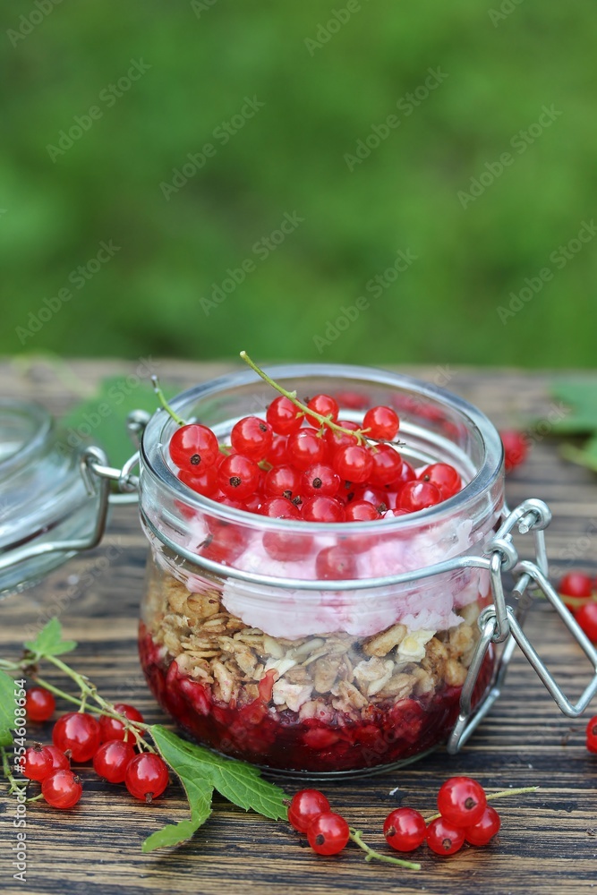 Sticker Healthy breakfast - muesli, muesli with yoghurt and fresh redcurrants.. Against the background of an old table with peeling paint. Country style