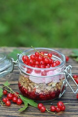 Healthy breakfast - muesli, muesli with yoghurt and fresh redcurrants.. Against the background of an old table with peeling paint. Country style