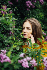 Naklejka premium Outdoor fashion photo of beautiful young woman surrounded by flowers. Spring blossom