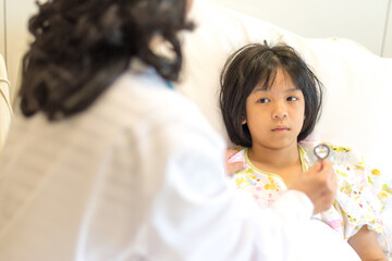 Asian sick kid patient or child inpatient on hospital bed with pediatrician doctor exam with...