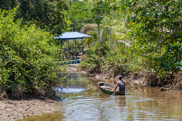 fisherman rowing with his boat at the river at Kampung Saradan