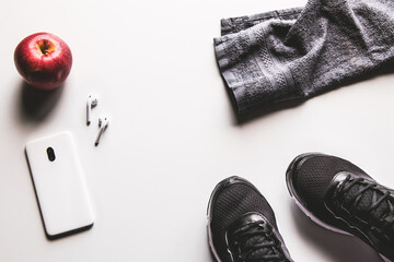 Mockup mobile cellphone with earphone and running shoes on white background. Healthy lifestyles